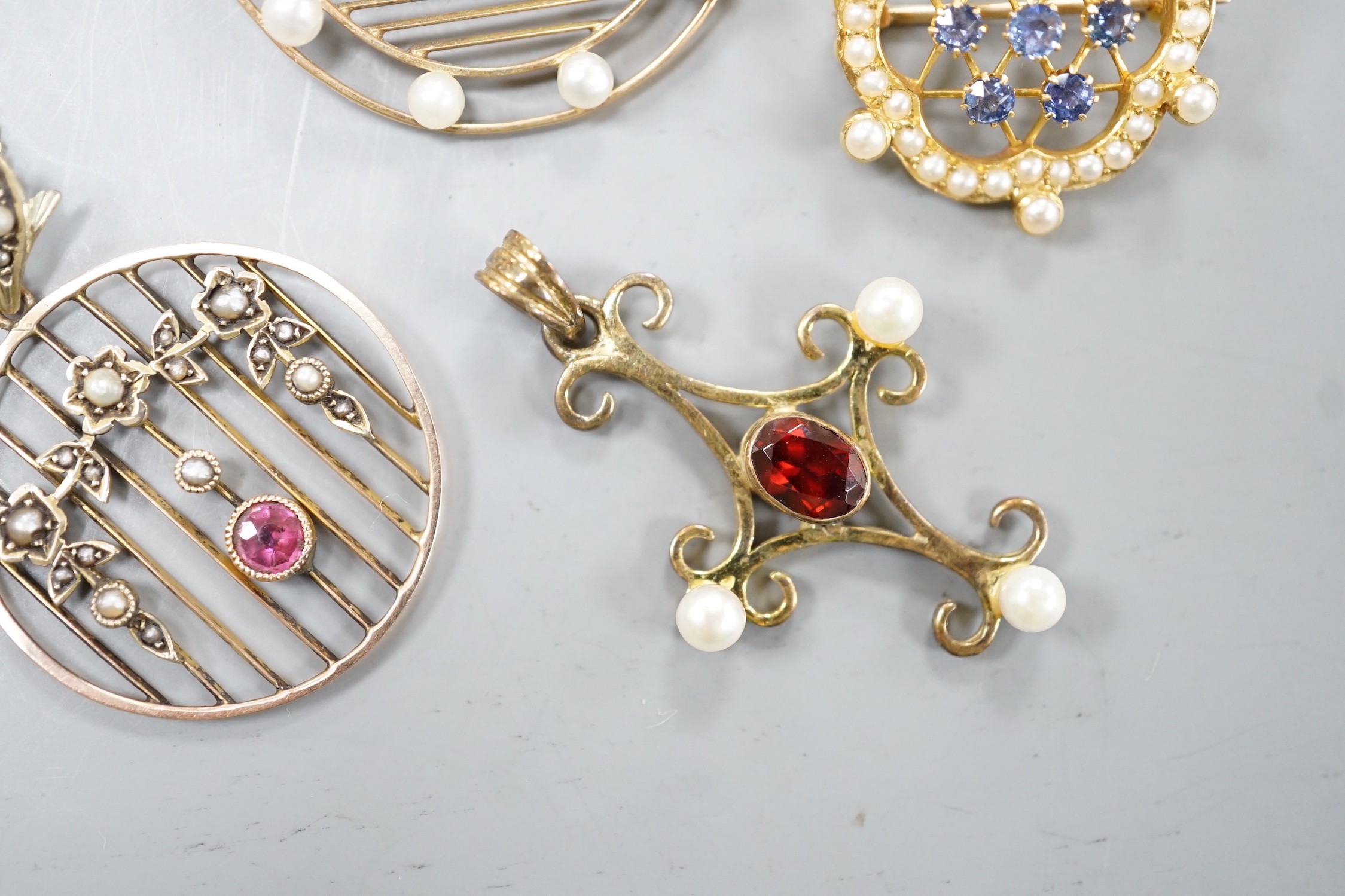 Three early 20th century yellow metal and gem set pendants or brooches, including sapphire and seed pearl, garnet and seed pearl and amethyst and seed pearl on chain and a later 375 garnet and cultured pearl set quatrefo